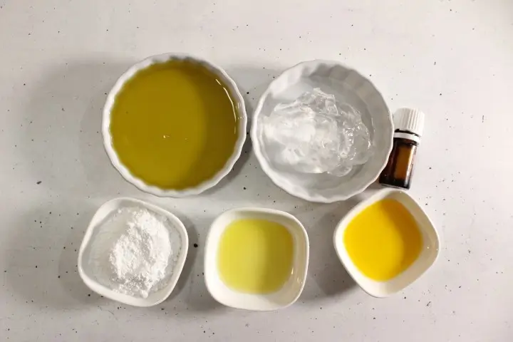 bowls of oils, zinc, and essential oil needed to make diy sunscreen spray