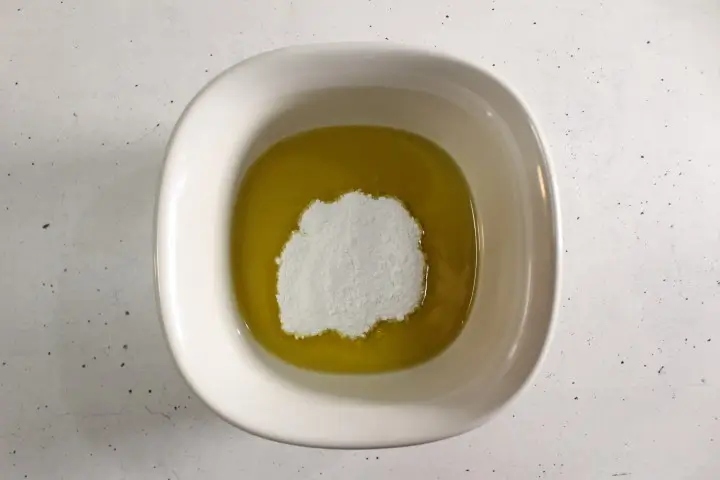 a bowl of oils with zin oxide powder to make a diy sunscreen spray