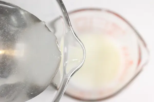Magnesium Tallow Lotion Balm DIY Recipe 21 pouring magnesium water into a tallow mixture to make a magnesium tallow balm