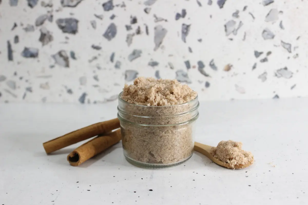 Cinnamon Sugar Scrub DIY 11 jar of homemade cinnamon sugar scrub with spoon and cinnamon sticks