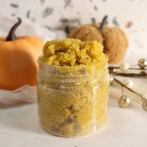 jar of homemade pumpkin spice sugar scrub with a pumpkin in the background