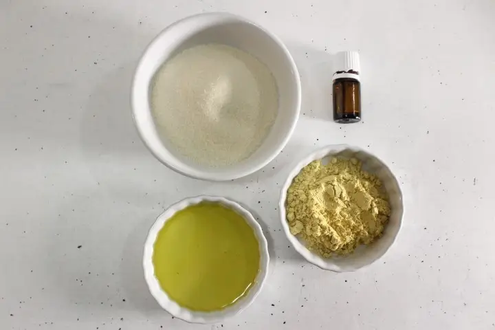 bowls of ingredients and bottle of essential oil to make pumpkin spice sugar scrub