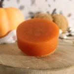 homemade bar of pumpkin spice soap on a wooden board