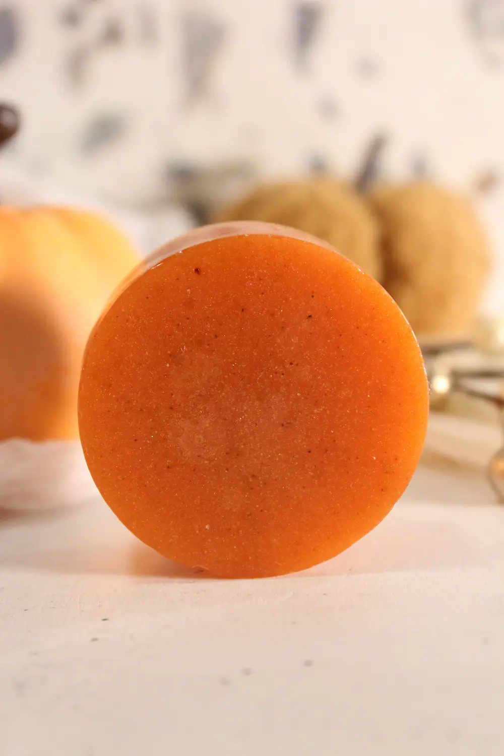 bar of homemade pumpkin spice soap in a fall setting