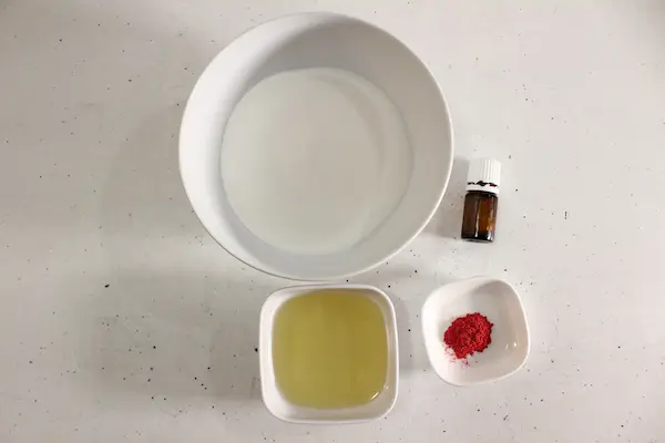 bowls of ingredients and essential oil to make candy cane sugar scrub