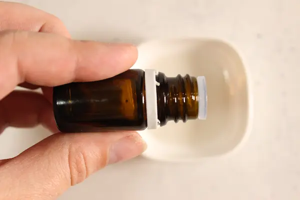 Charming Christmas Tree Bath Bombs Recipe 15 adding essential oil to a bowl for making homemade Christmas Tree Bath Bombs