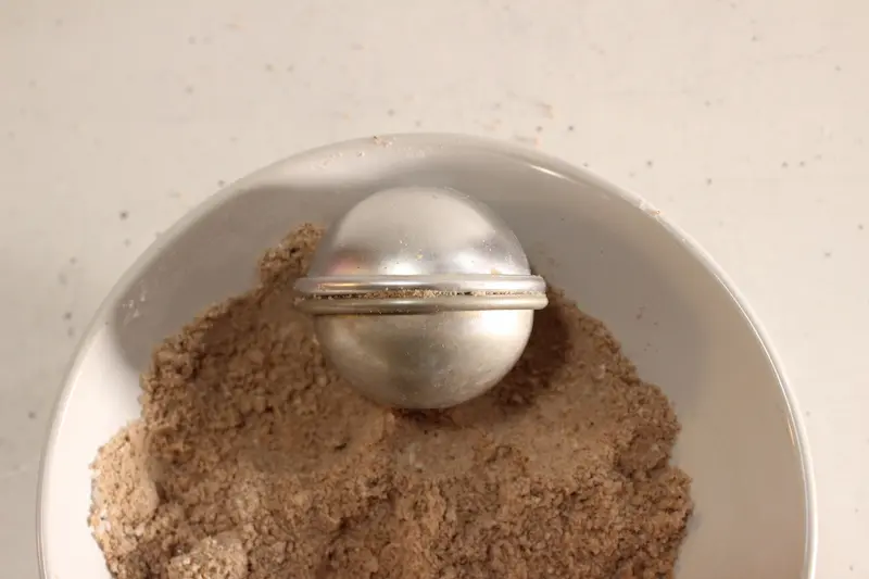 Rose Chocolate Bath Bomb Recipe 22 bath bomb mold inside a bowl filled with chocolate bath bomb mixture