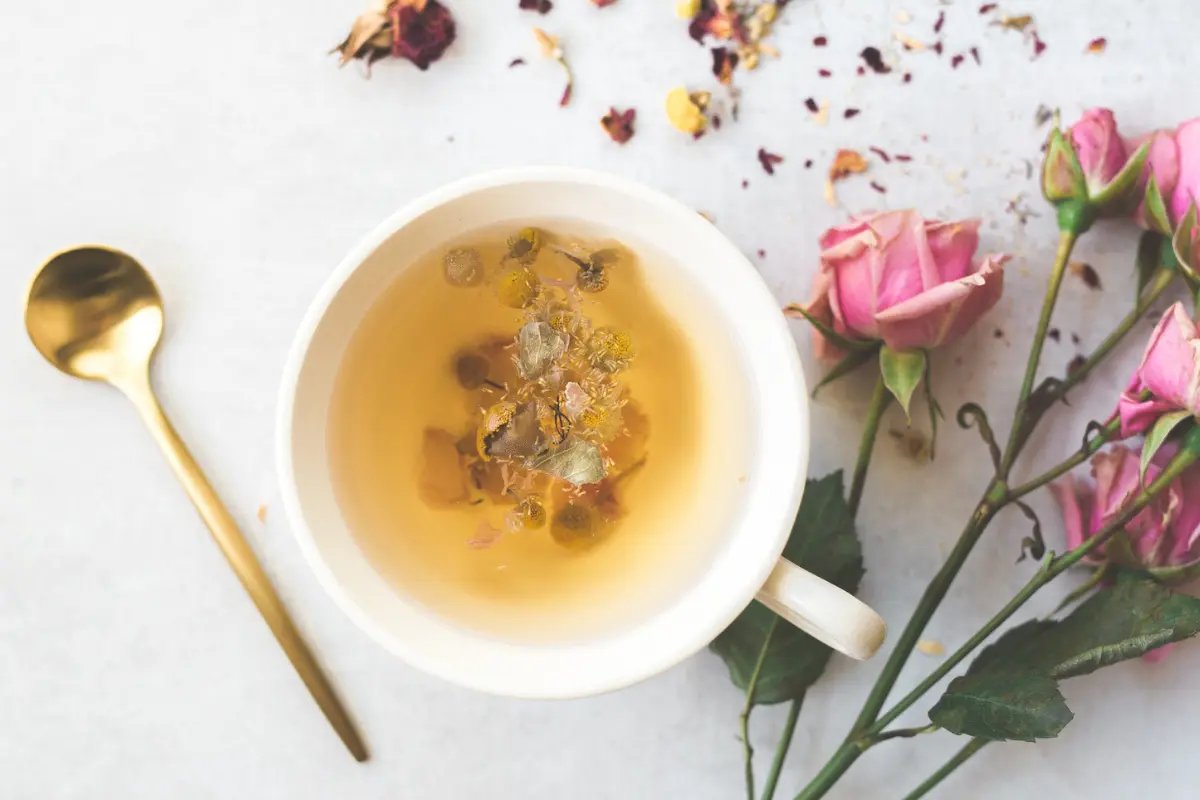 Calming Bedtime Tea Recipes For Sleep 11 a pretty mug of tea for sleep with a gold spoon with florals