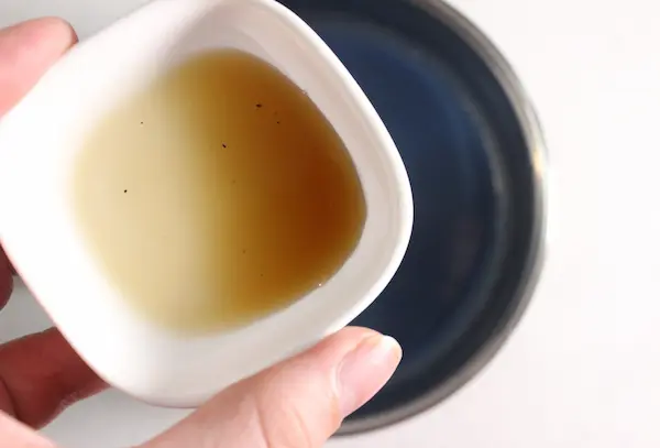 Blue Moon Milk Recipe with Butterfly Pea Flower and Ashwagandha For Sleep and Stress 18 bowl of vanilla extract being added to blue moon milk