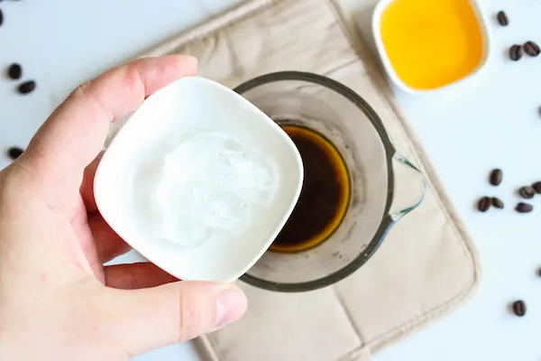 Under Eye Coffee Patches DIY Recipe 16 a bowl of coffee and a hand pouring a bowl of aloe vera into the coffee to make diy coffee eye patches