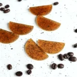 homemade coffee eye patches on a white counter with coffee beans scattered around