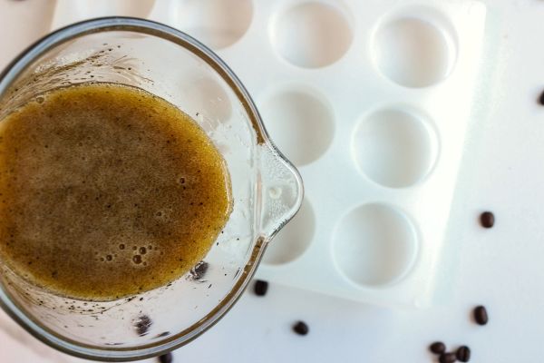 Under Eye Coffee Patches DIY Recipe 21 a measuring cup of coffee mixture pouring into a silicone mold for diy eye patches