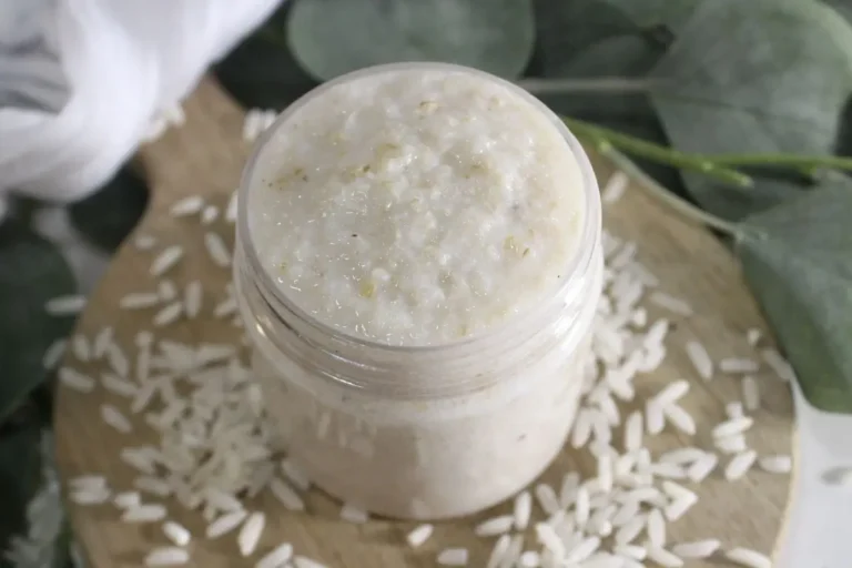 jar of diy rice face mask on wood with rice scattered around