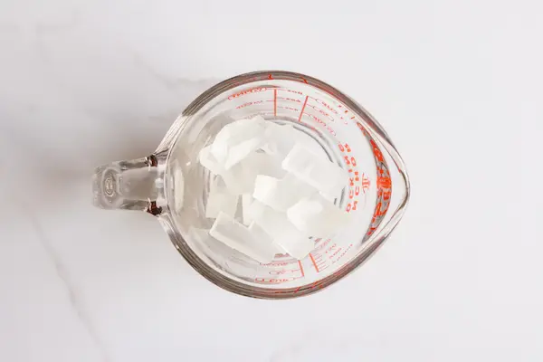 glass pyrex measuring cup filled with glycerin soap base cubes for making easter bunny soap