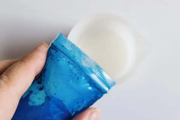 DIY Floral Soap Bars - an impressive handmade gift 25 an envelope of blue mica powder being added to melted soap base