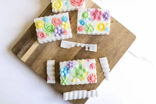 DIY Floral Soap Bars - an impressive handmade gift 37 wooden cutting board with homemade floral soaps with the edges being cut off with a wavy soap cutter