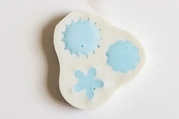 DIY Floral Soap Bars - an impressive handmade gift 28 a small flower soap mold with blue soap base in it