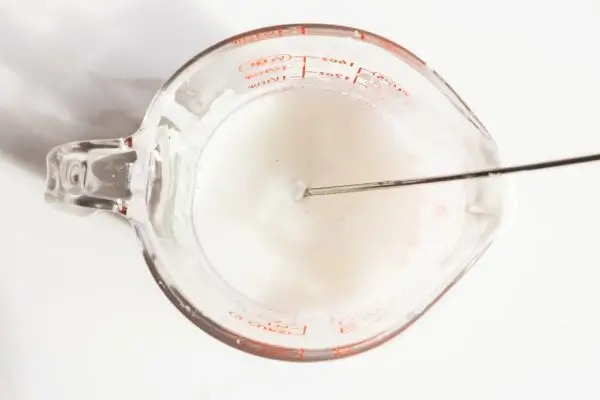 DIY Floral Soap Bars - an impressive handmade gift 32 a glass measuring cup filled with melted soap base and a whisk